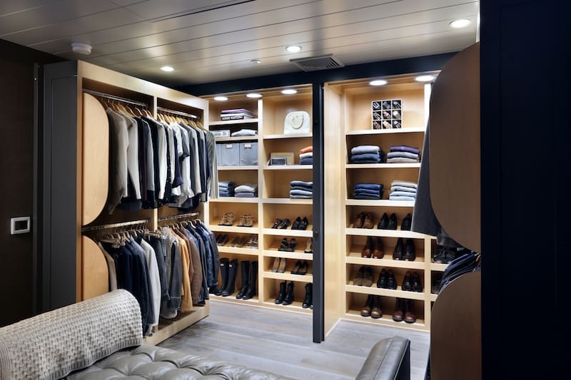 Spacious walk-in closet with shoe racks and hanging clothes in a stylish home.