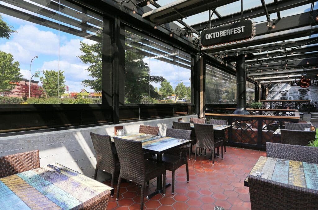 Exterior shot of restaurant with Phantom Retractable Screens fully deployed, creating an enclosed and inviting dining space for outdoor dining in Greater Vancouver.